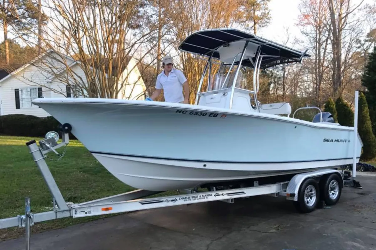 White Sea Hunt boat on trailer being cleaned in driveway