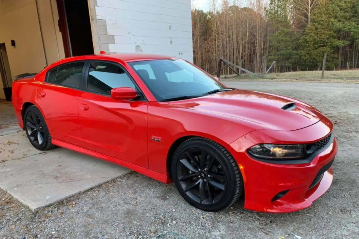 A red car parked outside with a clear view of its side profile.