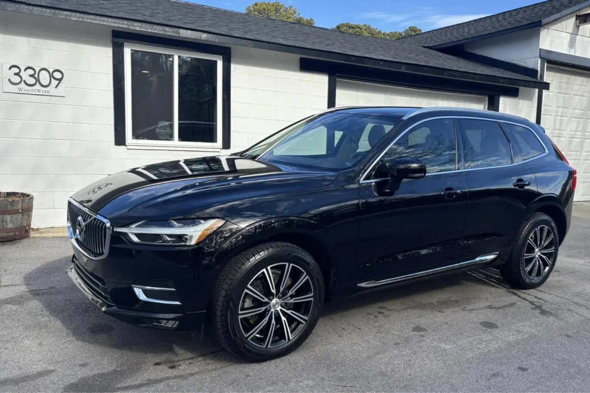 Black car parked in front of garage with clean polished exterior